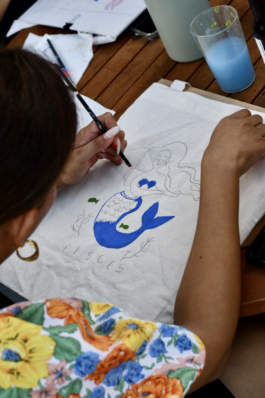 Persona pintando una tote bag