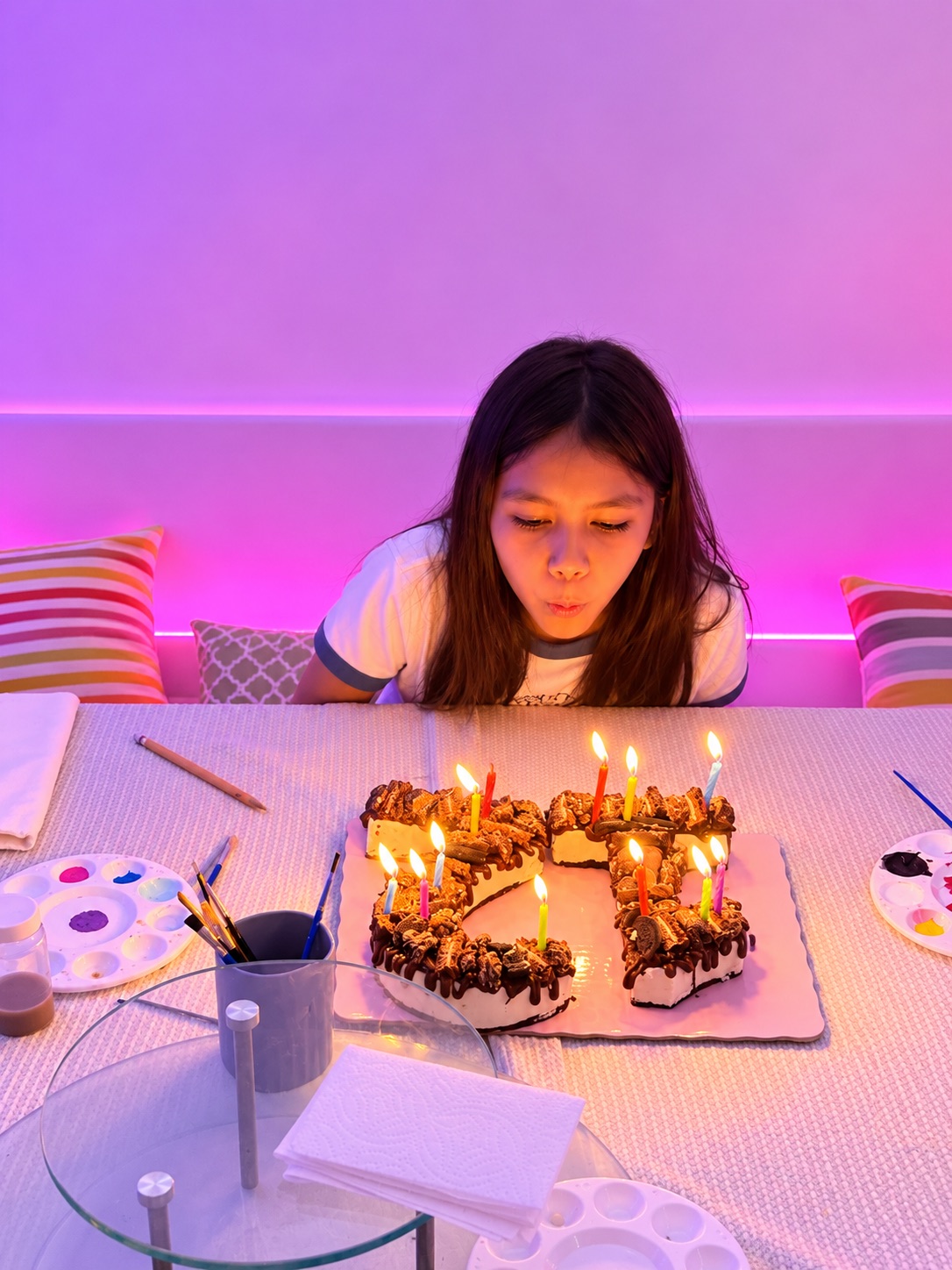 Cumpleañera soplando las velas de su pastel en el local Art D'ler